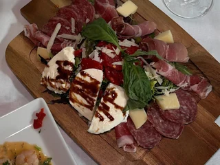 Olive & Oak's cold antipasto board with cured meats, cheese, roasted peppers and greens
