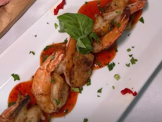 Olive & Oak's Shrimp & Fire in red sauce with basil on a rectangular white plate